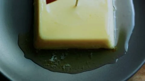 Appetizing tabletop study of lifting a bite from the square flan Stock Photos
