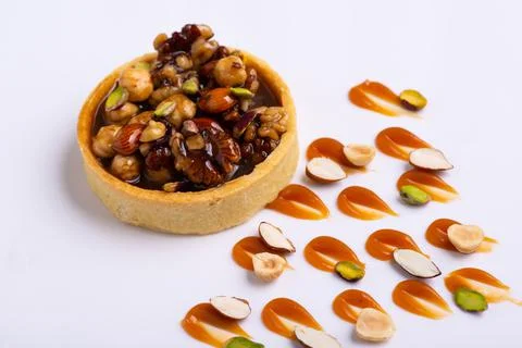 Appetizing tartlet stuffed with hazelnuts walnuts covered with a layer of liquid Stock Photos