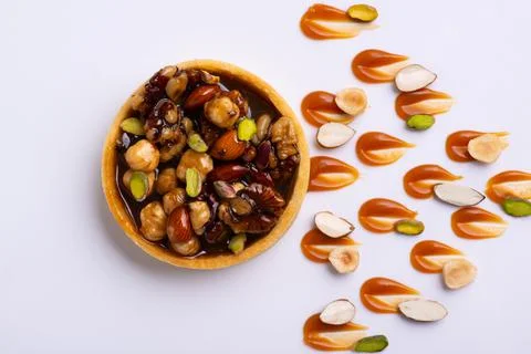 Appetizing tartlet stuffed with hazelnuts walnuts covered with a layer of liquid Foto stock