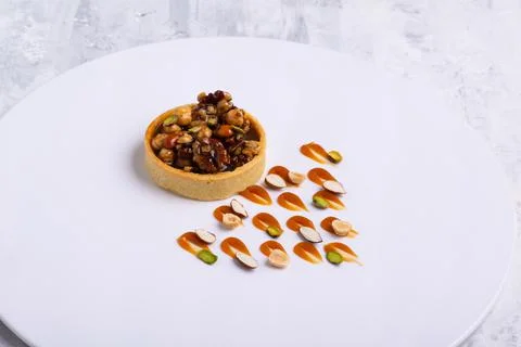 Appetizing tartlet stuffed with hazelnuts walnuts covered with a layer of liquid Foto stock