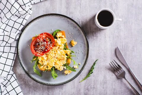 Appetizing toast with scrambled egg, tomato and sesame seeds on a plate top.. Stock Photos