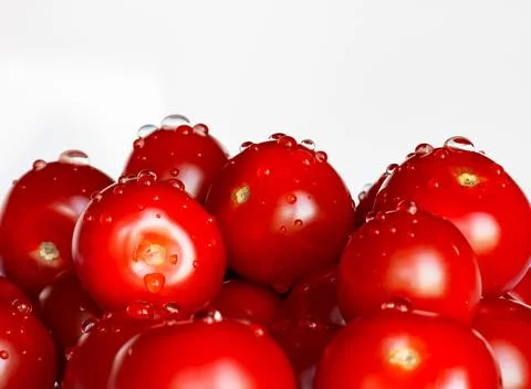 Appetizing tomatoes with drops of water isolated on a white background. Copy  Stock Photos