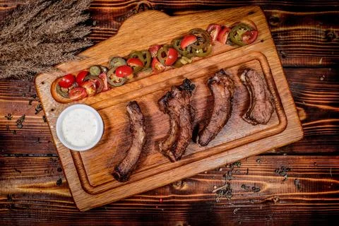 Appetizing Top view: Irish Pub-Themed Grill Ribs - Wooden board with sauce,.. Fotos Stock