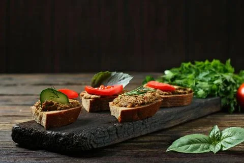 Appetizing Vegetable Pate Toasts with Tomato and Herbs on Wood 写真素材