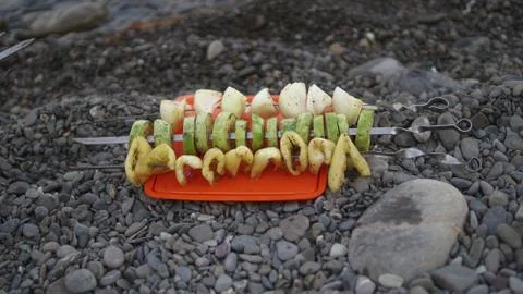 Appetizing vegetables is fried on the grill on the pebble beach. 写真素材