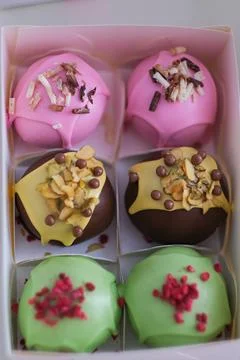 Appetizing view of a box of colorful cake pops with various toppings. Sweet Foto stock