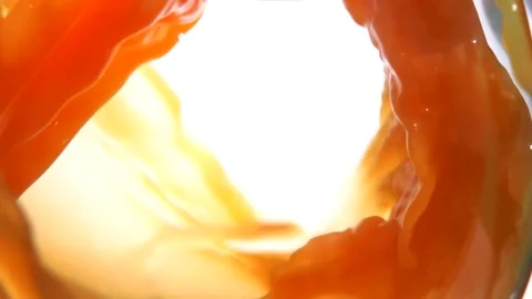An appetizing wave of mango juice swirls inside the glass Stock-Footage 258560204