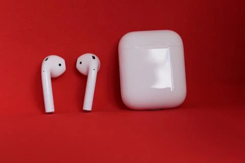 Apple Airpods Isolated On Red Background Stock Photos