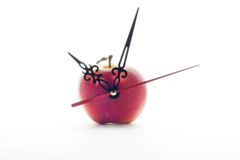 Apple and clock hands on white background Stock Photos
