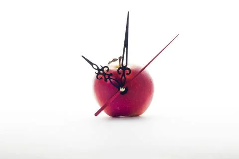 Apple and clock hands on white background Stock Photos