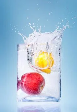 Apple and orange in water splashes Stock Photos
