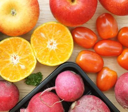 Apple beetroot orange and red tomatoes on wooden table Stock Photos