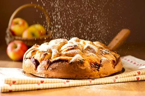 Apple cake being dusted with icing sugar Stock Photos