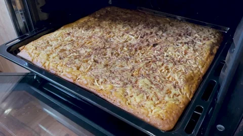 Apple charlotte on a baking sheet in the oven Stockbeeldmateriaal 337514497