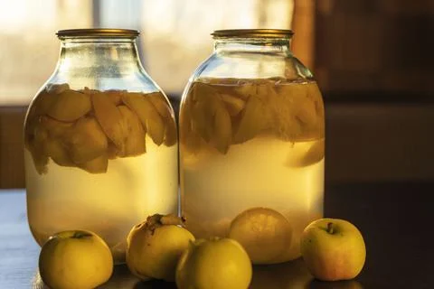 Apple compote in glass jars on the kitchen table, soft evening light Stock Photos