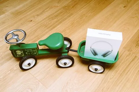 Apple Computers AirPods Max over-ear headphones on toy tractor Foto stock