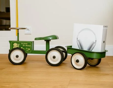 Apple Computers AirPods Max over-ear headphones on toy tractor 写真素材