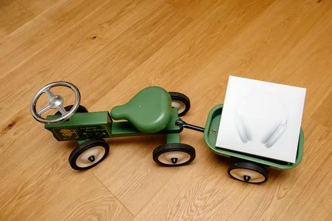 Apple Computers AirPods Max over-ear headphones on toy tractor 写真素材