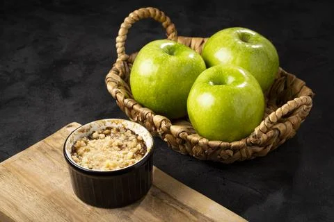 Apple crumble in ramekin on the table. Stock Photos