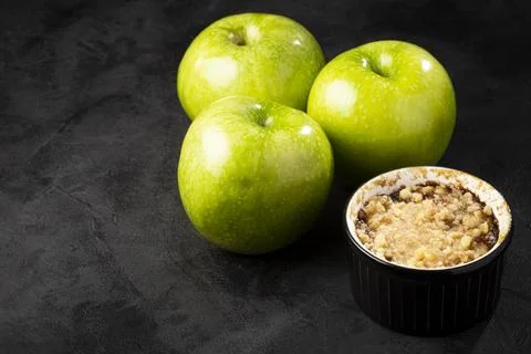 Apple crumble in ramekin on the table. Stock Photos