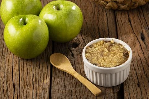 Apple crumble in ramekin on the table. Stock Photos