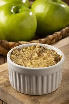 Apple crumble in ramekin on the table. Stock Photos