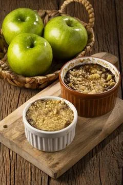 Apple crumble in ramekin on the table. Stock Photos