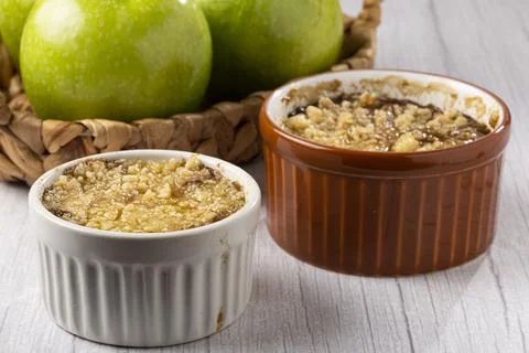 Apple crumble in ramekin on the table. Stock Photos