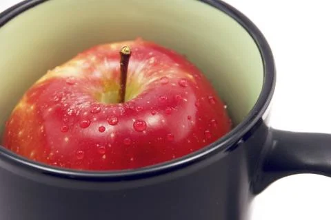Apple in a cup isolated on white Stock Photos