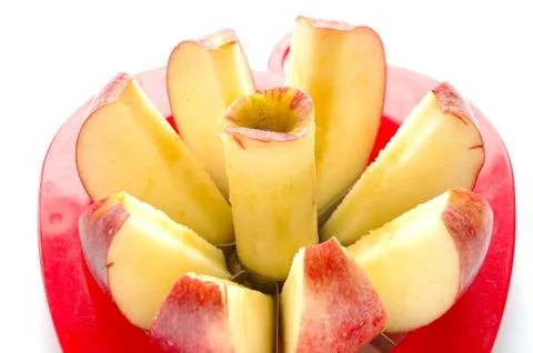 Apple cut into pieces with special cutting device on white background Stock Photos