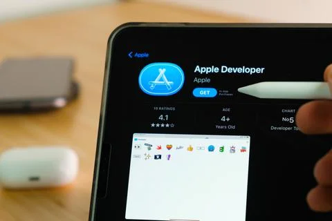 Apple Developer logo shown by apple pencil on the iPad Pro tablet screen. Man Stock Photos
