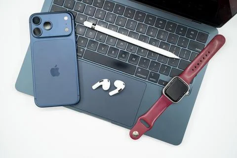 Apple ecosystem devices including iPhone iPad MacBook AirPods and smartwatch. Stock Photos