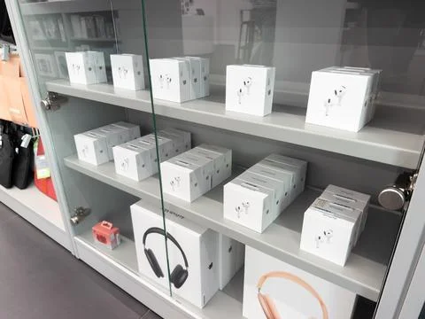 Apple electronics displayed on shelves inside a retail store case, showcasing 스톡 사진
