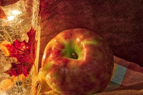 Apple in a fall theme with light and napkin. Photos