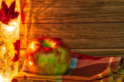Apple in a fall theme with light and napkin and a wood background providing c 스톡 사진