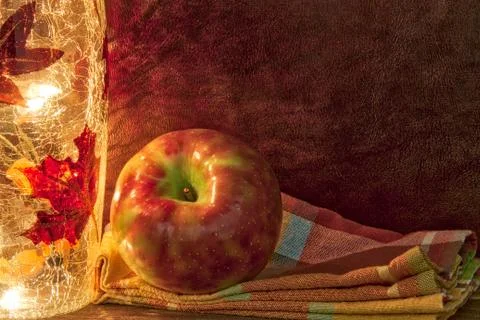 Apple in a fall theme with light and napkin and copy space. 스톡 사진