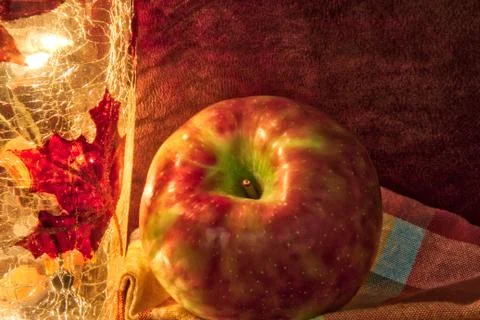 Apple in a fall theme with light and napkin. Photos