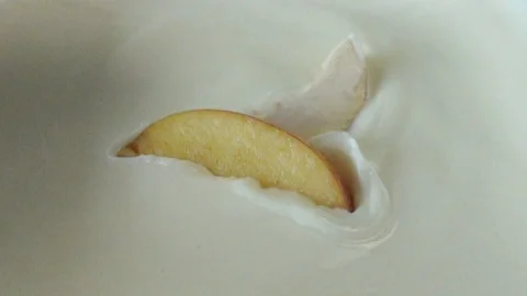 Apple falling to yogurt full hd slow motion close up video. Stock Footage 109474810