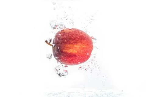 Apple falls under water with a splash. Stock Photos