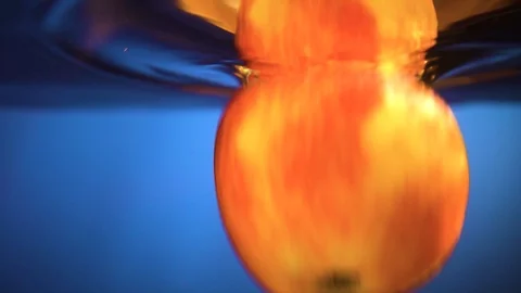 The Apple falls into the water. Red Apple falls down into the water, close-up Stock Footage 102468437