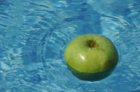 Apple floating at the swimming pool  Stock Photos