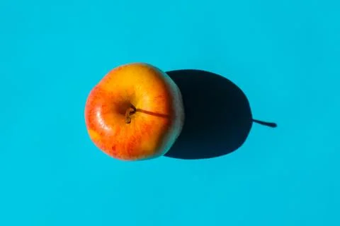 An Apple with a hard shadow on a plain background. the view from the top. blank Photos
