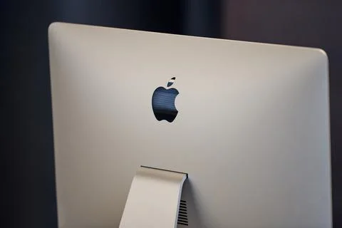 Apple iMac modern computer. Apple logo on monitor, workplace in office. New h 스톡 사진