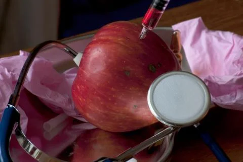 Apple injected with a red solution Stock Photos