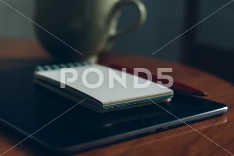 Apple iPad, cup of coffee and notebook on wood Stock Photos