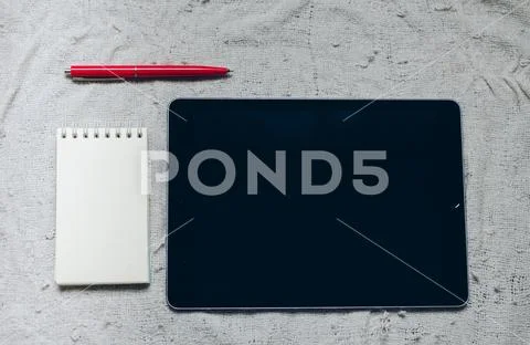 Apple iPad, pen and notebook on plaid. Stock Photos
