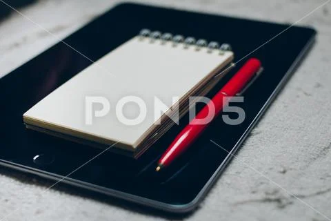 Apple iPad, pen and notebook on plaid. Stock Photos