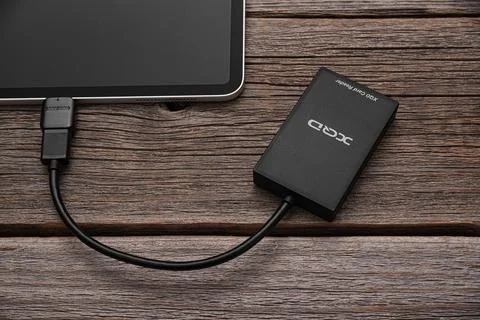 A Apple Ipad Pro with an XQD memory card connected via OTG via a card reader. Stock Photos