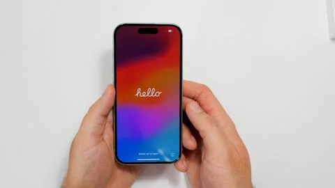 Apple iPhone 15 with Hello text welcome screen. Brand new iPhone in new green Stock Photos