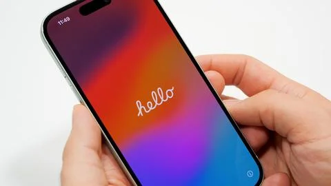 Apple iPhone 15 with Hello text welcome screen. Brand new iPhone in new green Stock Photos